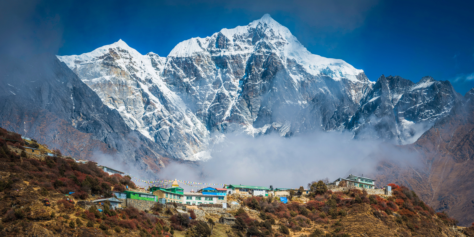 Snowy mountain peak towering over Sherpa teahouses Khumbu Himalayas Nepal